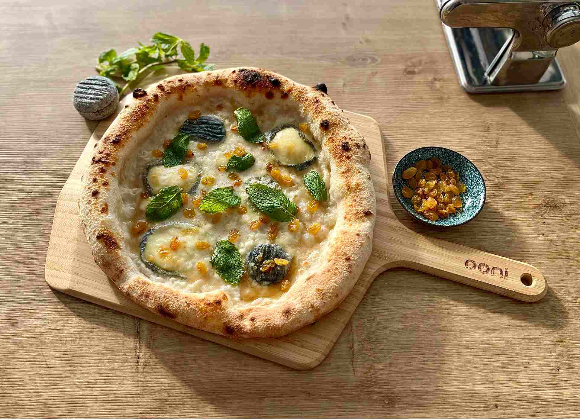 Vegetarian pizza with goat cheese, spiced honey, raisins and fresh mint recipe — Ooni Canada