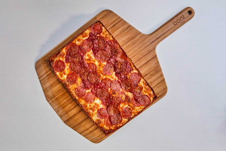 Detroit-style pizza with pepperoni on an Ooni Bamboo Peel & Serving Board.