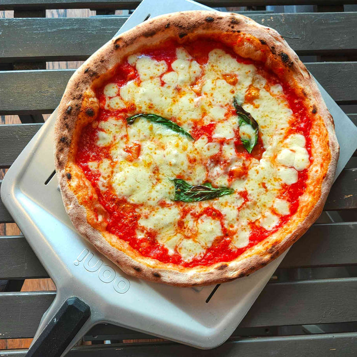 A pizza topped with cheese and tomato made with a pizza beer dough