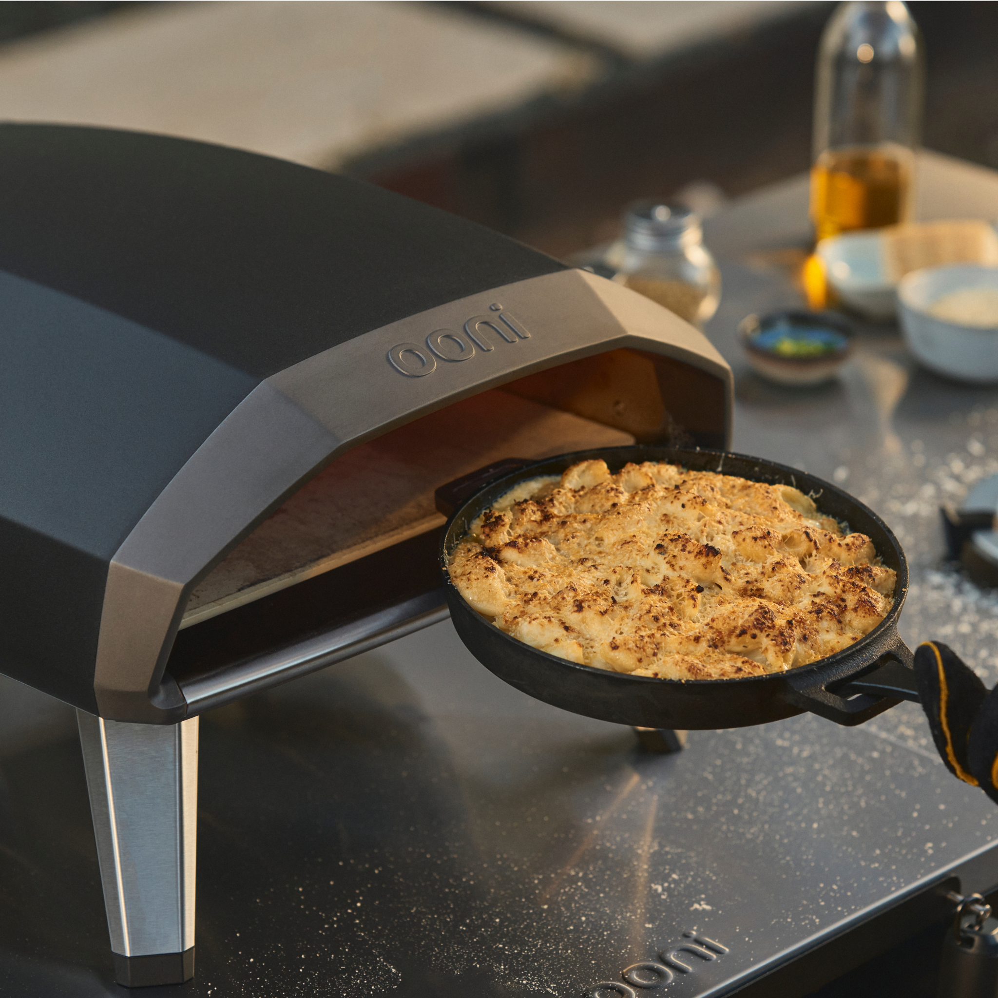Cast iron skillet with macaroni entering Ooni Koda 2 Gas powered oven