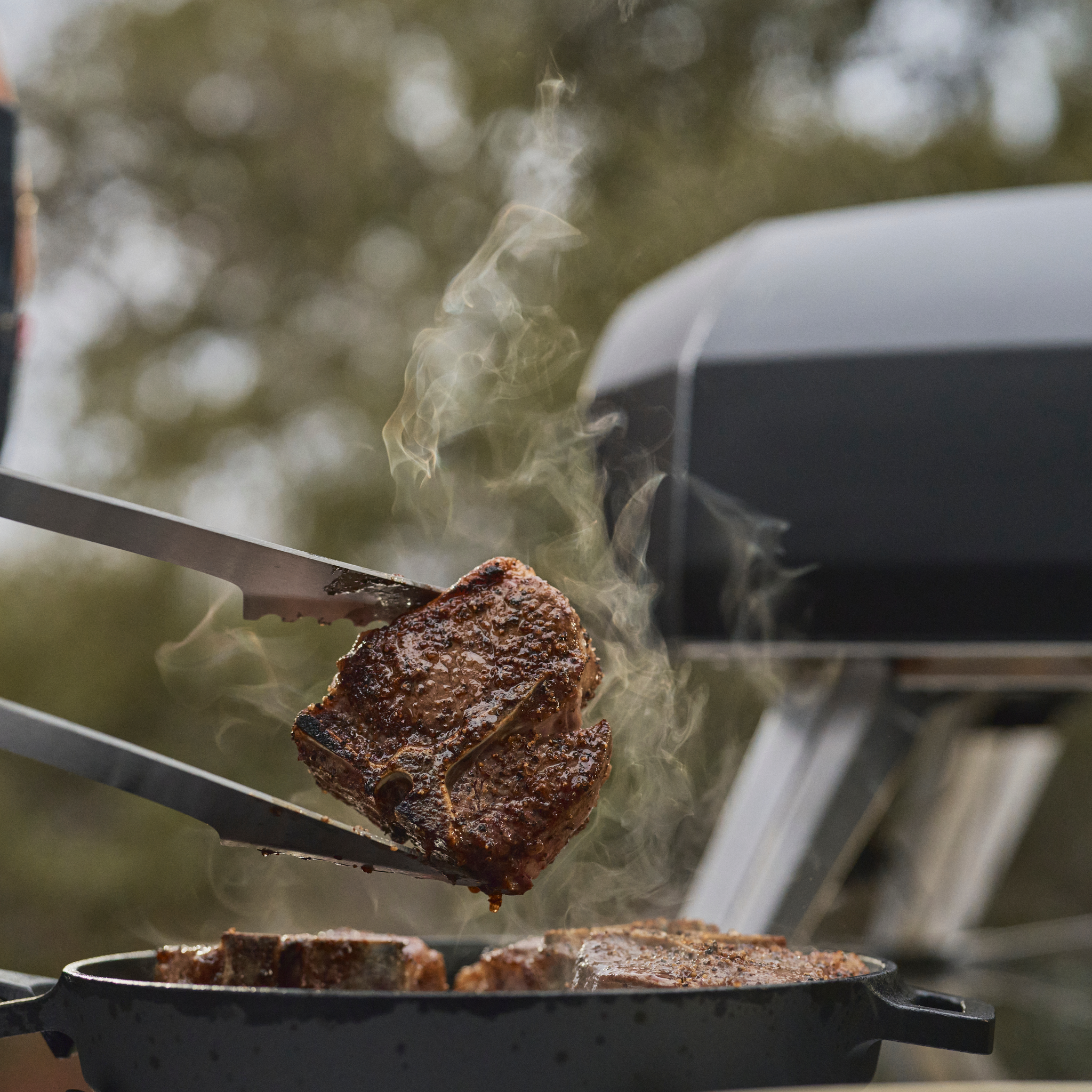 steak being cooking in a cast iron pan in the ooni koda 2 pro. 